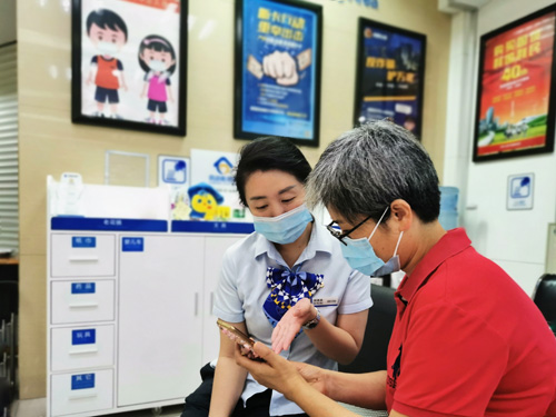 建行成都第六支行，大堂經(jīng)理為客戶(hù)介紹手機銀行“大字”模式